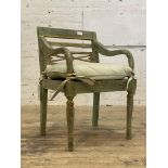 A 19th century style hardwood elbow chair, finished in distressed green and gilt paint. H87cm.