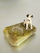 A 1930s cold painted bronze seated wire haired fox terrier candle stand with green onyx base some