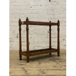 An early 20th century walnut stick stand, two divisions and complete with drip tray. H68cm, L71cm.