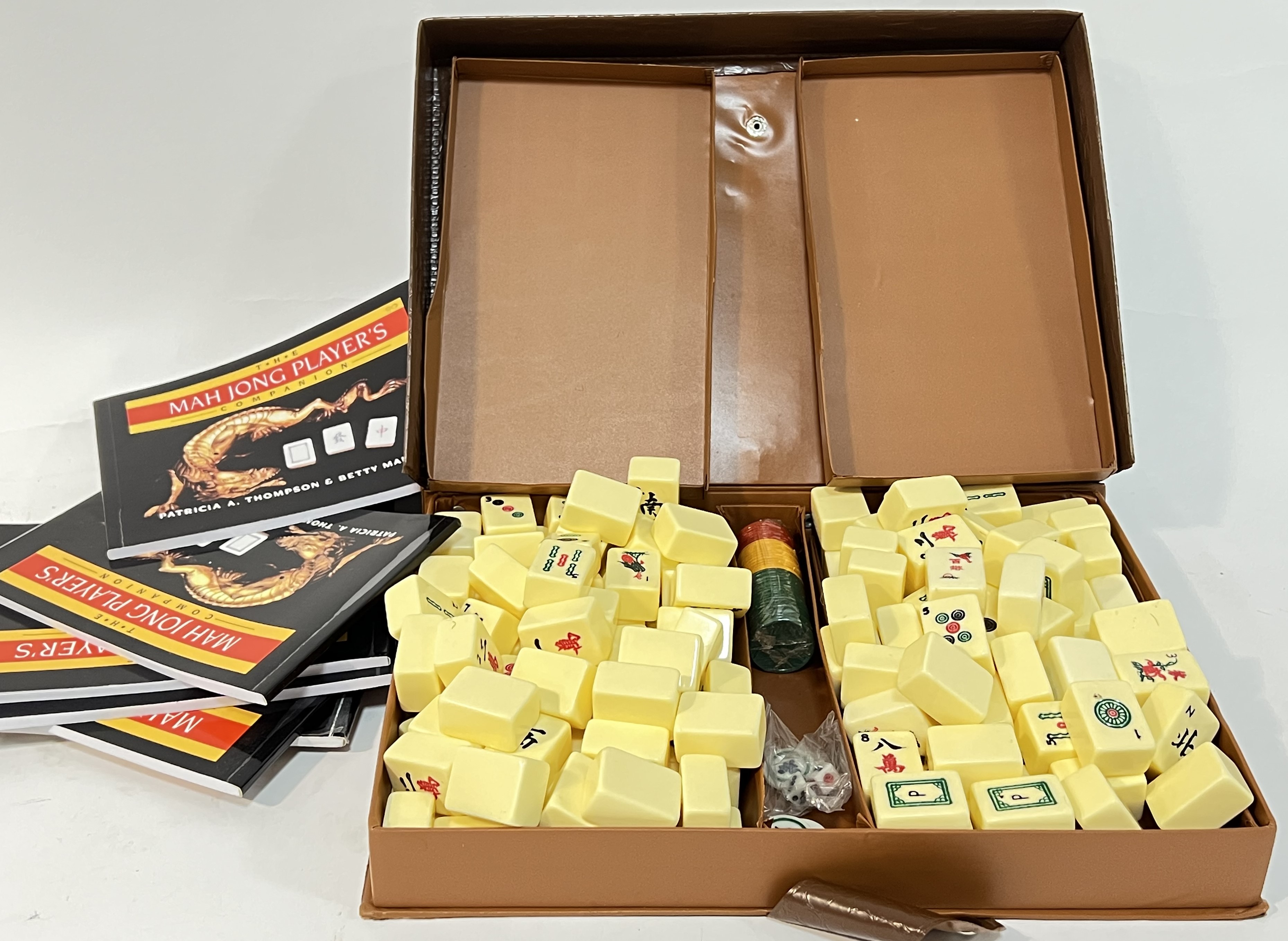 A complete mah-jong set with counters and player's companion booklets, housed in an embossed leather