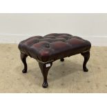 A vintage footstool, upholstered in buttoned oxblood leather and raised on cabriole supports. H30cm,