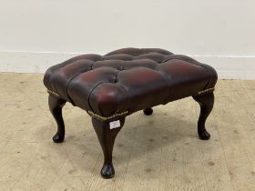 A vintage footstool, upholstered in buttoned oxblood leather and raised on cabriole supports. H30cm,