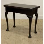 A George III Irish mahogany fold over tea table, the top raised on cabriole supports with paw carved