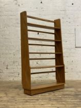 Ercol, an elm open bookcase shelf, with two fixed and two adjustable shelves on tapered panel end