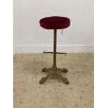 A Victorian style cast iron bar stool, circular velvet upholstered seat raised on a floral and paw