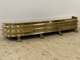 A 19th century brass bow front fire fender standing on paw supports. L134cm, D30cm.