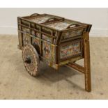 A 20th century drinks trolley of cart form, with brightly painted decoration. H63cm, L104cm.