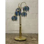 A Vintage brass floor lamp, four branches with coloured glass shades formed as lotus flowers.