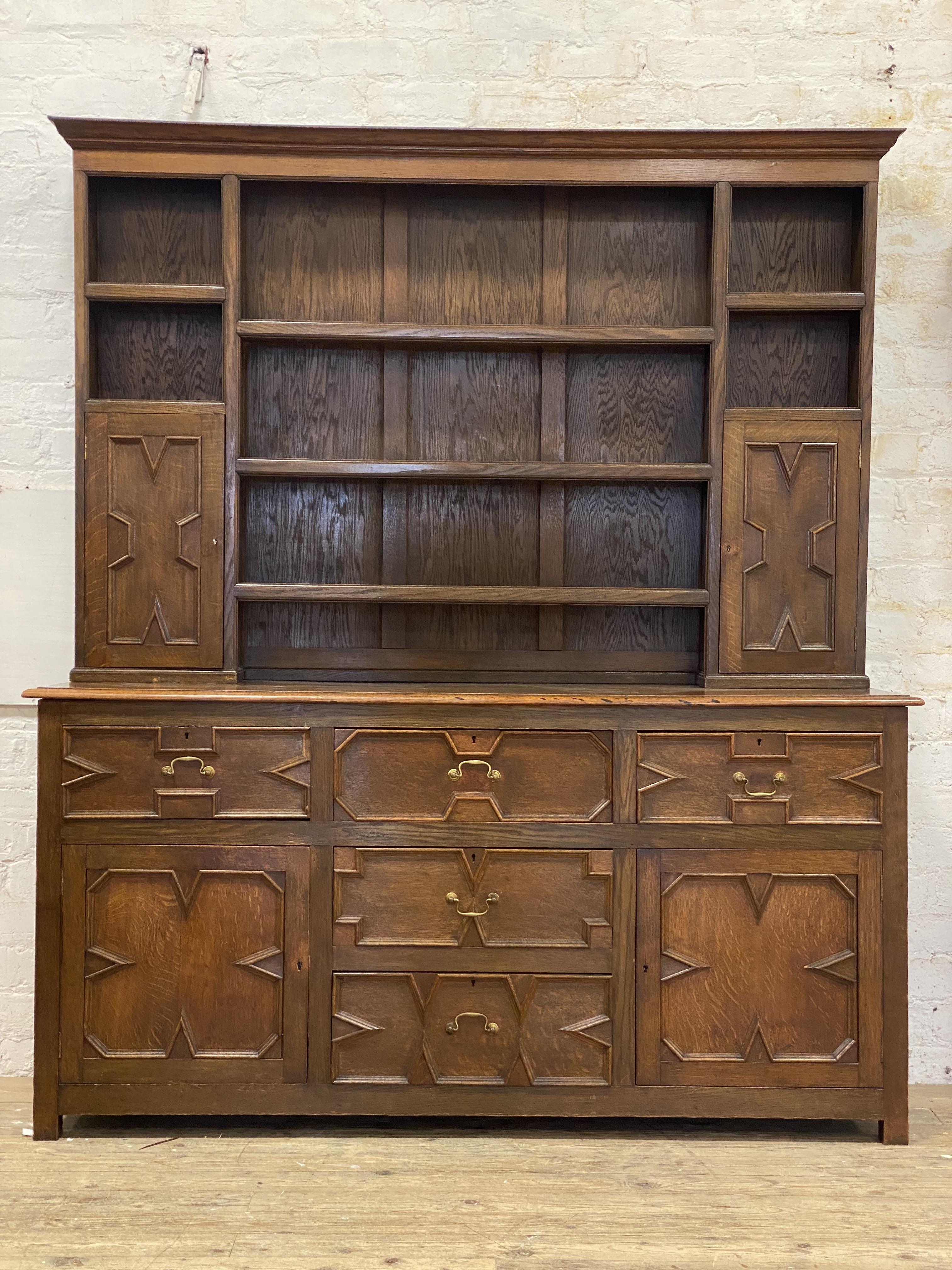 An oak dresser of 17th century design, the plate rack with five open shelves and two geometric