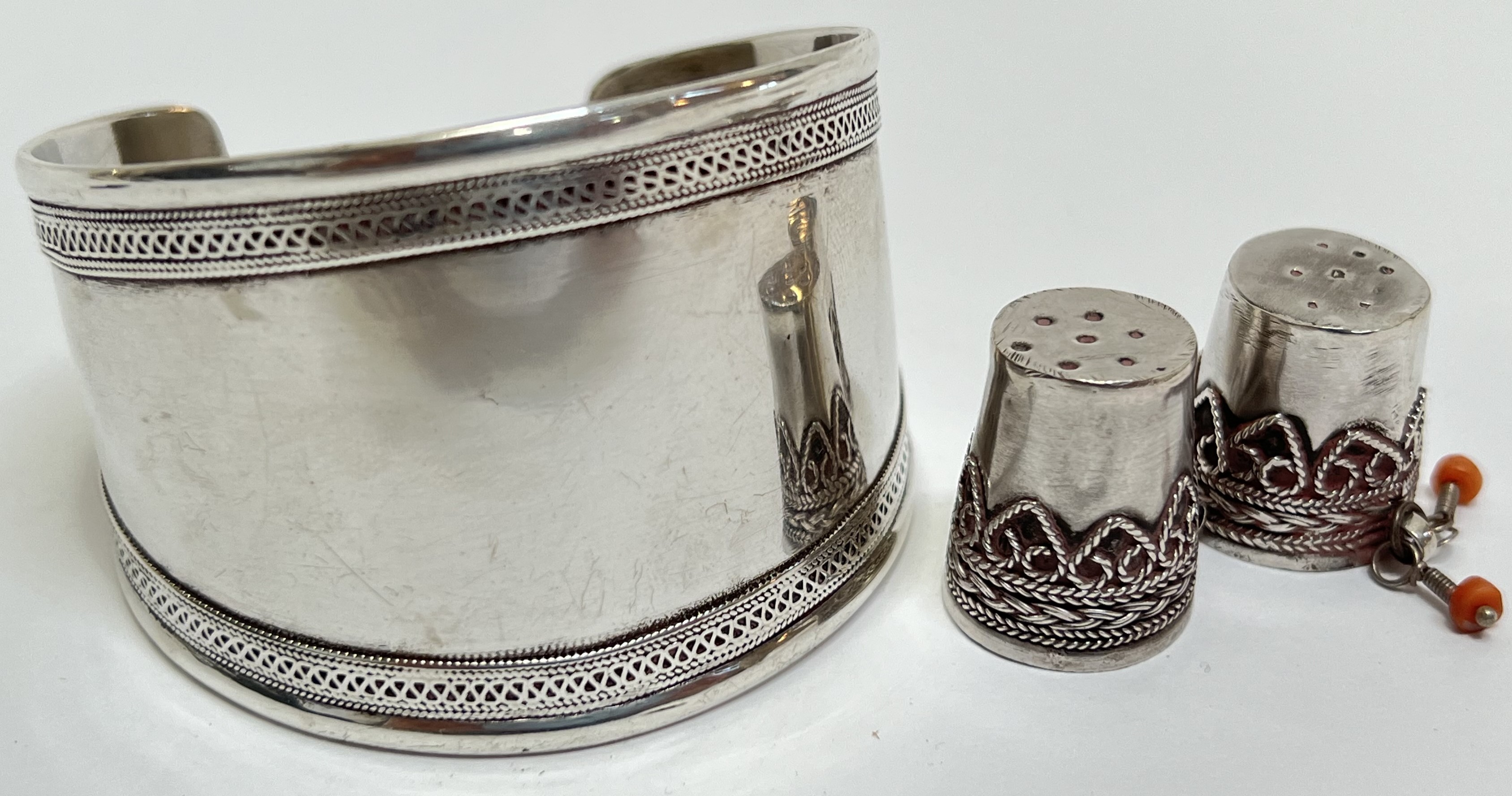 A pair of middle Eastern/Indian white metal thimbles with filigree decoration and coral elements,