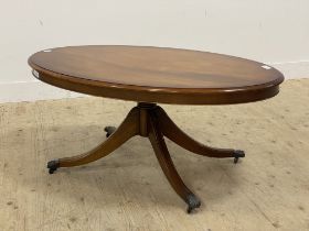 A Regency style mahogany coffee table, the oval cross banded top raised on a turned column and
