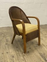 An early 20th century LLoyd loom chair, with bentwood arms, sprung upholstered seat and raised on