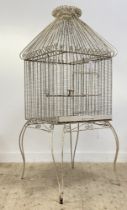 A large Vintage garden wirework bird cage, with 's' scrolled pitched top and raised on shaped