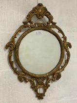 A gilt composition wall mirror in the Rococo taste. 62cm x 45cm.