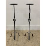 A pair of wrought iron pricket type candle sticks. H81cm.