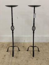 A pair of wrought iron pricket type candle sticks. H81cm.