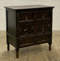 An early 20th century oak chest of Jacobean design, with three geometric panelled drawers, raised on