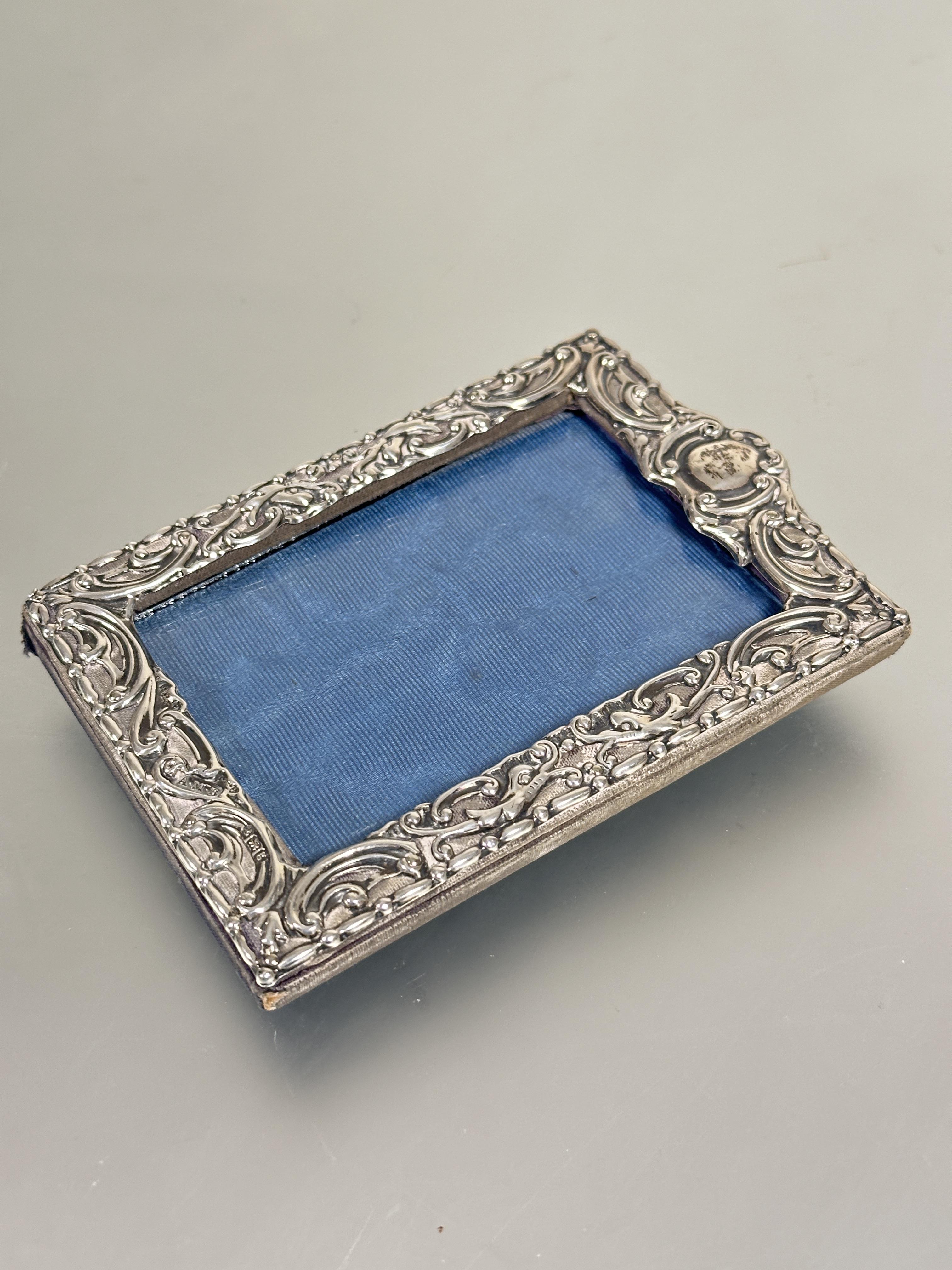 A Edwardian silver chased photograph frame of rectangular form with allover C scroll design