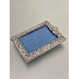 A Edwardian silver chased photograph frame of rectangular form with allover C scroll design