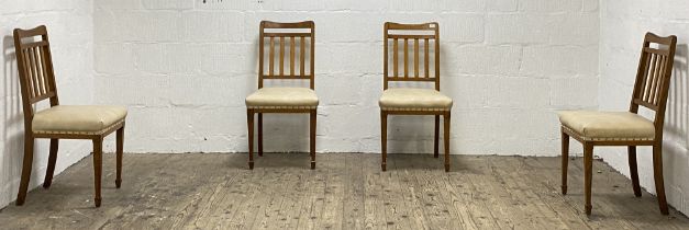 Maple & Co. A set of four Edwardian oak dining chairs, with leather upholstered seat pads and raised