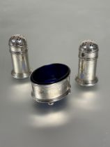 A Birmingham silver three piece condiment set comprising pair of domed pierced top pepperettes