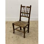 An ash and beech child's chair in the Arts and Crafts style, 20th century, with spindle back, string