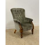 A Victorian mahogany framed armchair, upholstered in buttoned green velvet and raised on turned
