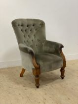 A Victorian mahogany framed armchair, upholstered in buttoned green velvet and raised on turned