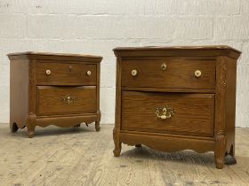 A pair of American oak two drawer bedside chests of serpentine outline. H64cm, W67cm, D45cm.
