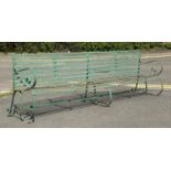 A large riveted strapwork iron garden bench, first half of the 19th century, with scrolling arms and