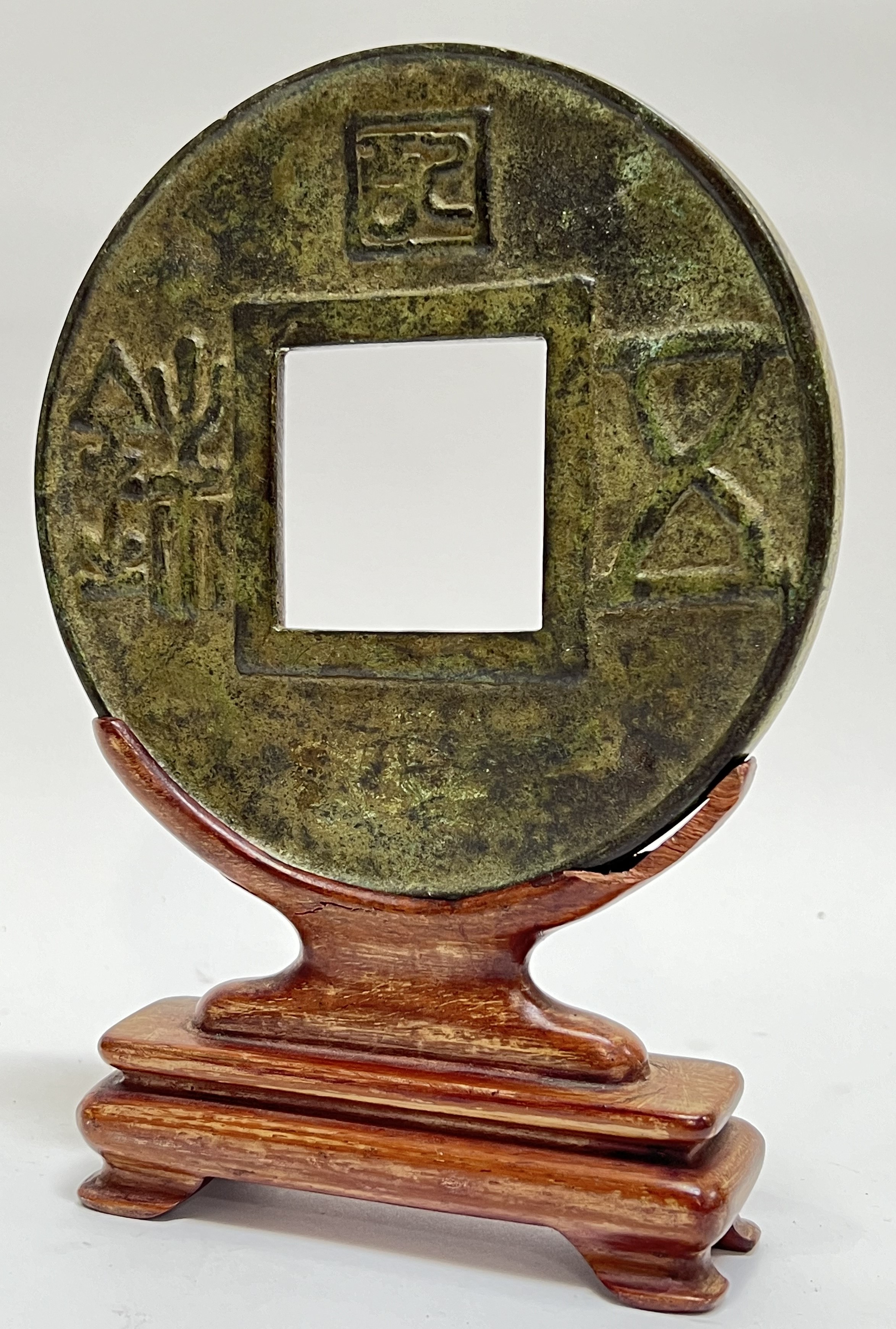 A Chinese cast bronze model of a cash token with stand (total height- 20cm)