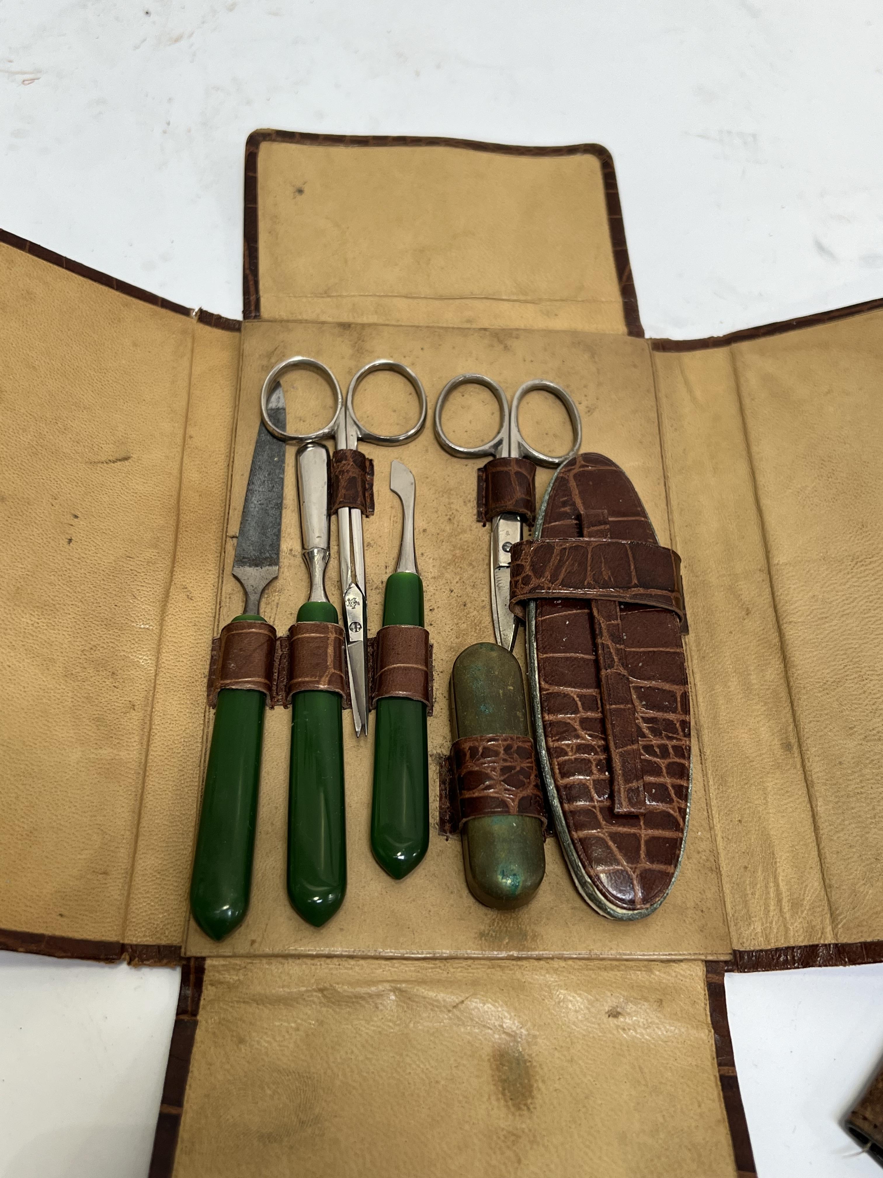 An embossed leather manicure kit containing early plastic/Bakelite handled accoutrements ( - Image 2 of 2