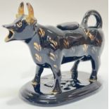 A Victorian Jackfield ware pottery/earthenware cow creamer, black glazed with gilt details (