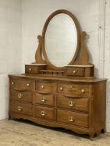 An impressive American oak vanity chest, with oval swing mirror above two drawers with simulated