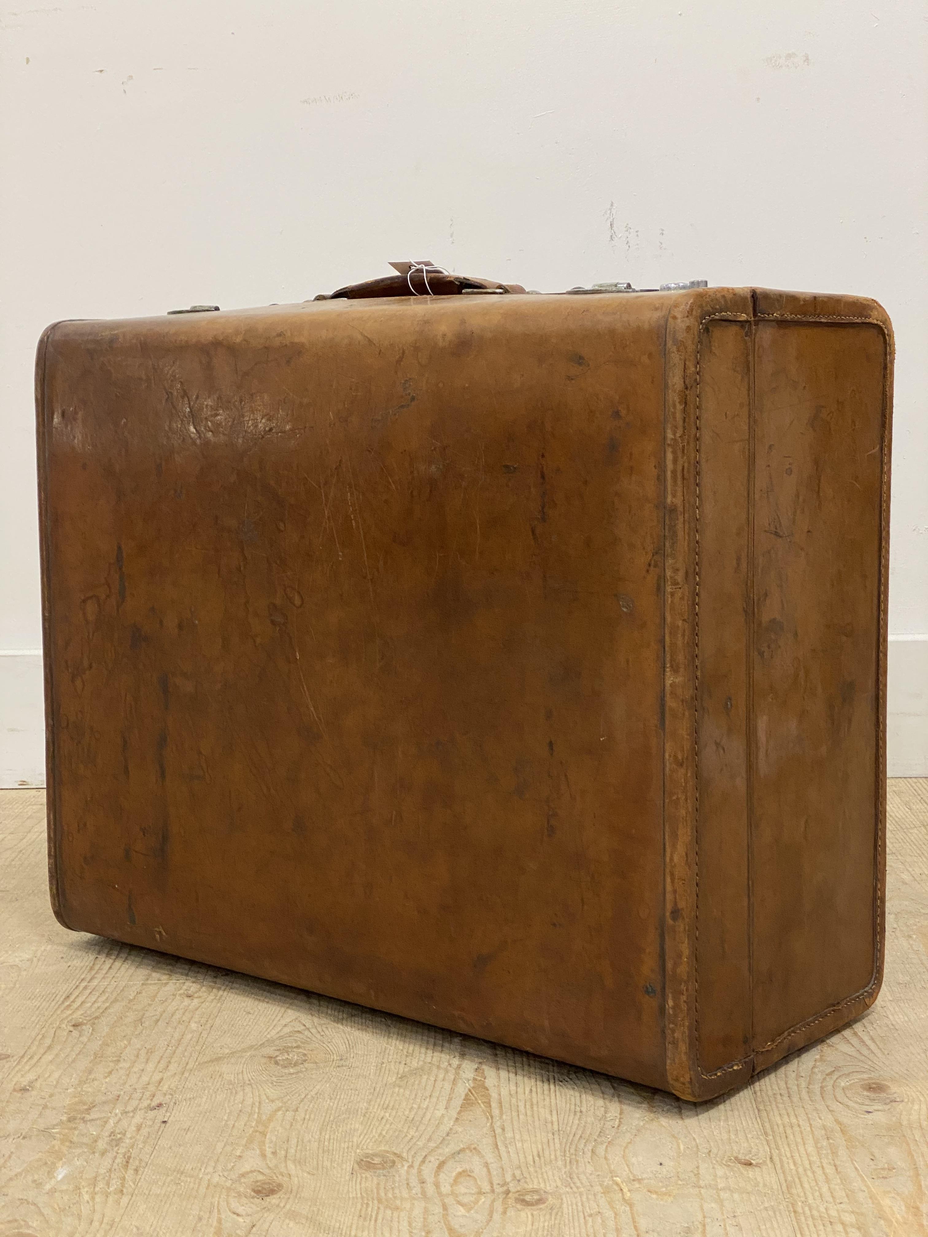 An early 20th century 'Rev-Robe' leather suitcase, with canvas lined and fitted interior, initialled