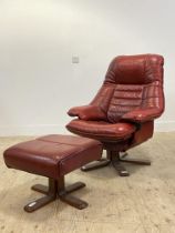A mid century Scandinavian style reclining chair upholstered in oxblood leather and raised on a