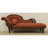 A Victorian mahogany framed chaise lounge with floral and pierce carved show frame enclosing red and