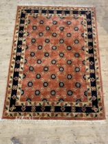 A hand knotted Persian Veramin design rug, the terracotta field with rosette motif and bordered.