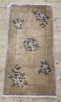 A Chinese silk and cotton knotted rug, the pale field with floral bouquets and bordered. 142cm x