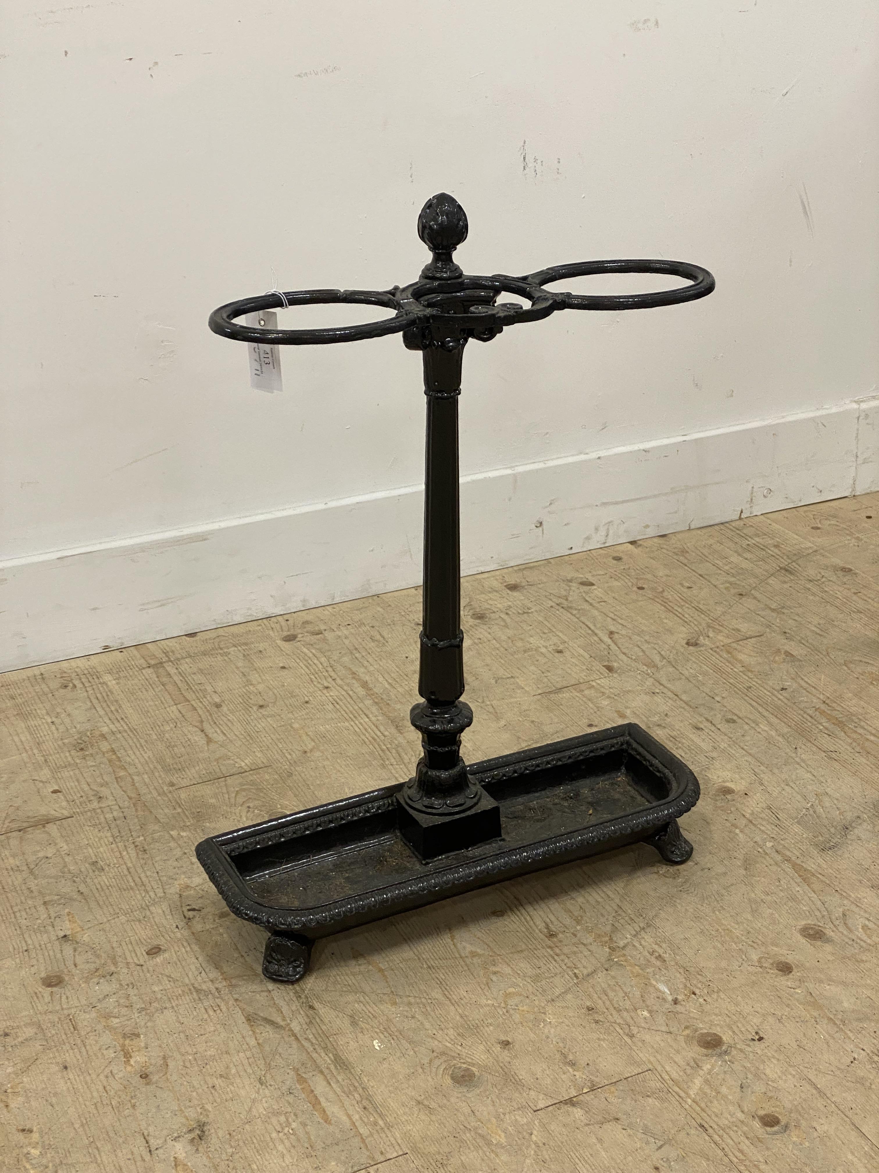 A Victorian cast iron stick stand, two divisions on an ionic column and above a drip tray, raised on