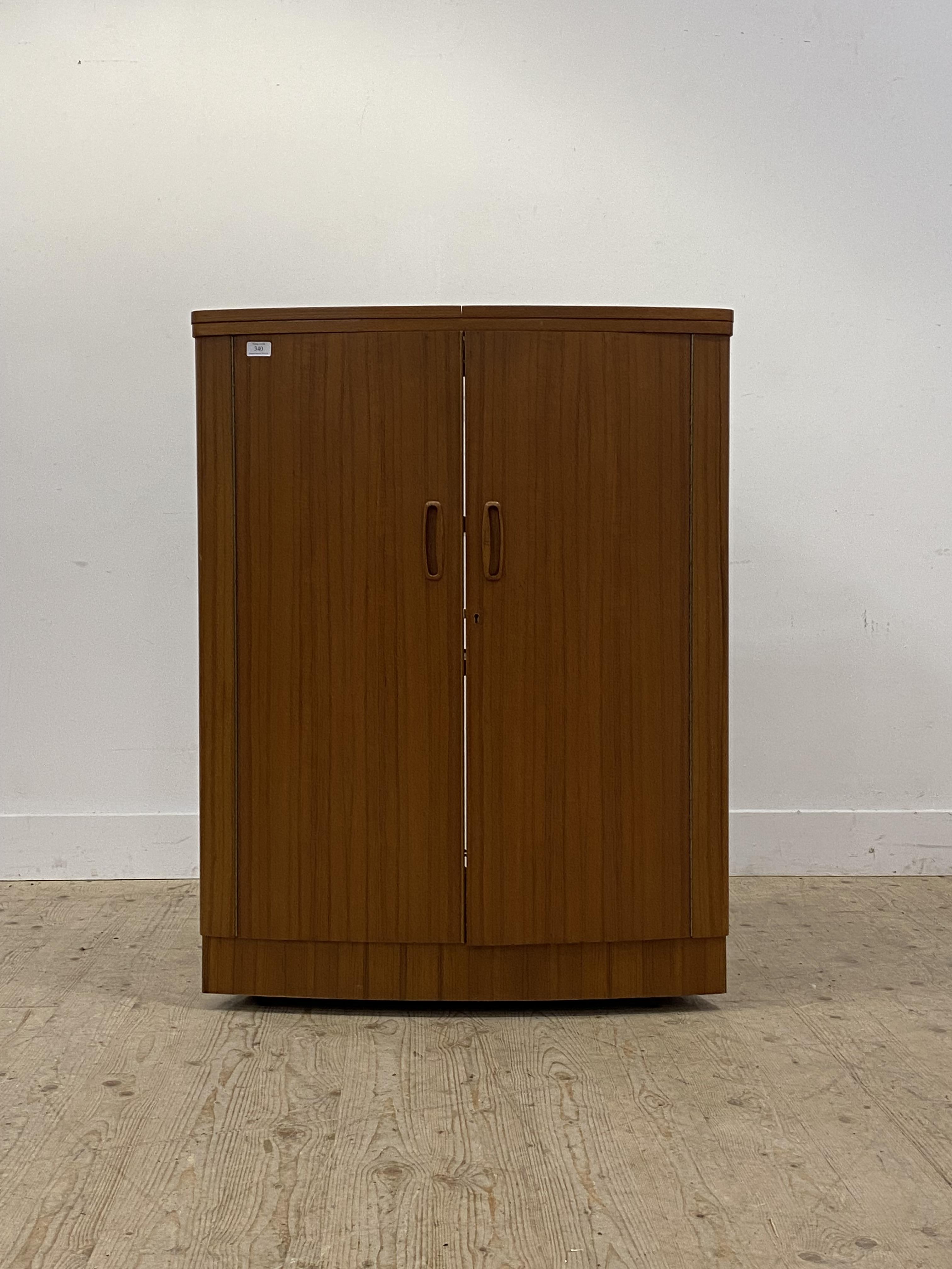 A mid century teak bow front cocktail cabinet / drinks bar, the top with fold over top to each side,