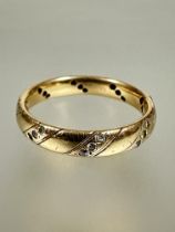 A 9ct gold ring with eight horizontal bands set three diamond points one stone missing 0/N 3.40g