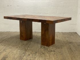 An Indonesian hardwood dining table, the rectangular top raised on two on two oblong pedestals.