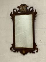 An Edwardian mahogany framed fretwork mirror, with pierce carved and gilt ho-ho bird. 47cm x 85cm.