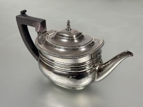 An Edwardian London silver morning tea pot of rounded oval design with finial and gadroon border and