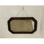 A 1930's carved oak wall hanging mirror. 82cm x 51cm.