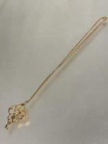 A Edwardian 9ct gold open work pendant set two peridot and and seed pearl leaves and flowers no