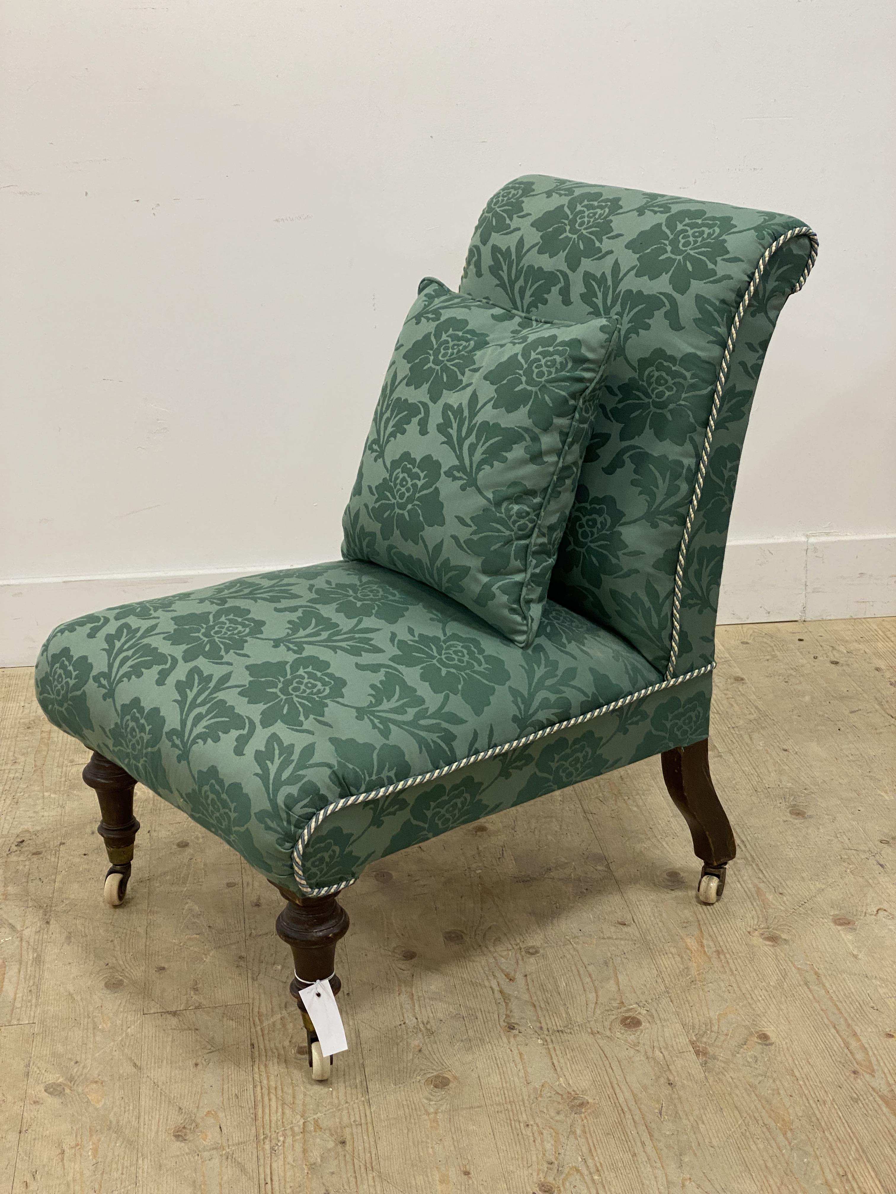 A Victorian bedroom chair, uphosltered in green floral cotton and raised on turned supports with