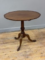 A 19th century mahogany tilt top table, the circular top with raised and moulded edge above a ring