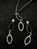 Diamond pendant and matching earrings with leaf design in 10k white gold setting on black rubber, es